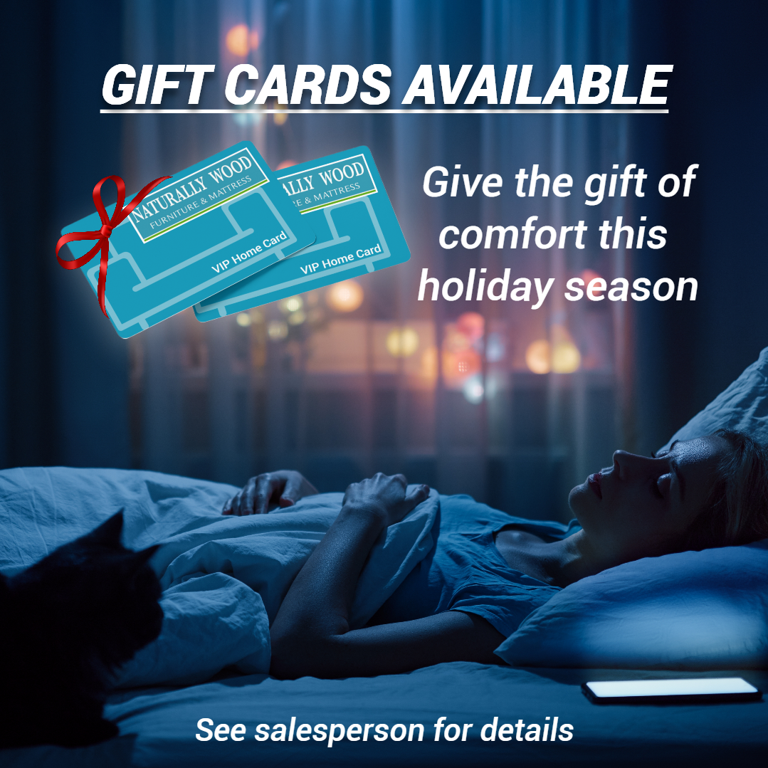 Gift cards available. Lady sleeping on mattress with holiday lights in background.